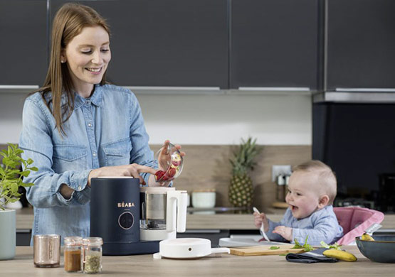 Mutter bereitet Essen für Kleinkind in Produkt der Firma BEABA