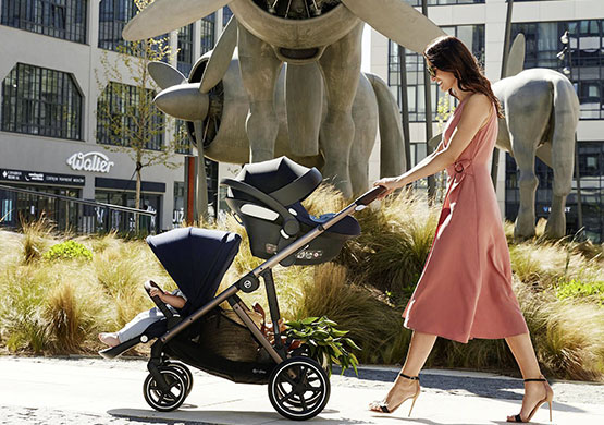 Frau mit einem Geschwisterkinderwagen der Firma Cybex