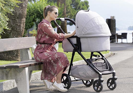 Frau mit einem Kombikinderwagen der Firma "Mast"