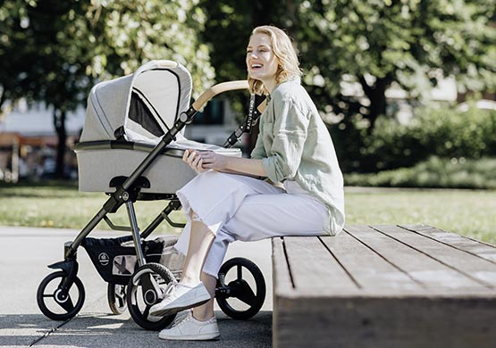 Frau mit einem Kombikinderwagen der Firma "naturkind"
