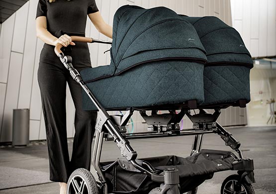 Frau mit einem Zwillingskinderwagen der Firma "Hartan"