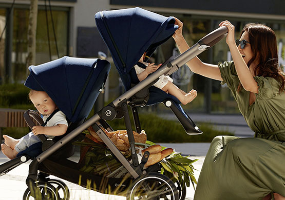 Frau mit einem Zwillingskinderwagen der Firma Cybex