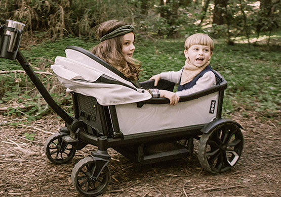Kinder unterwegs mit einem Bollerwagen der Firma Veer