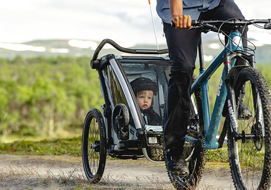 Ein Kind sitzt in einem Fahrradanhänger der Firma Thule